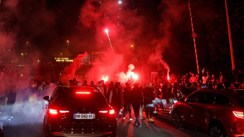 Los aficionados del Paris Saint-Germain (PSG) encienden bengalas y fuegos artificiales mientras bloquean la autopista cerca del Estadio Parque de los Príncipes.