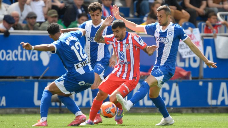 El delantero argentino del Atlético de Madrid, Ángel Correa, lucha por el balón con el defensa uruguayo del Alavés, Santiago Mourino, y Joan Jordan Moreno.