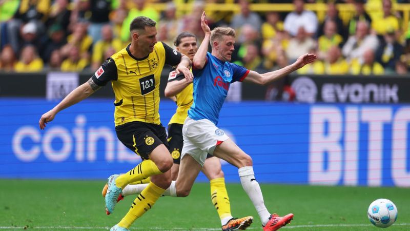 El defensa Niklas Süle disputando el balón con un delantero del Holstein Kiel.