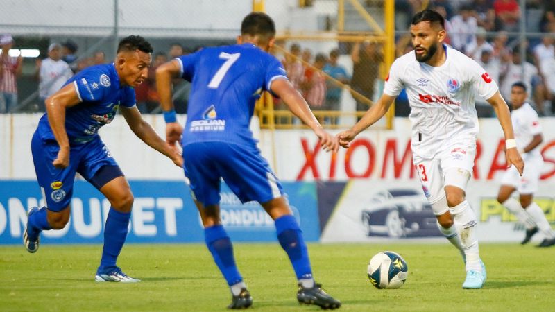 El mediocampista de Olimpia, Jorge Álavarez, enfrenta a Allan Banegas y Cristian Cálix del Victoria.
