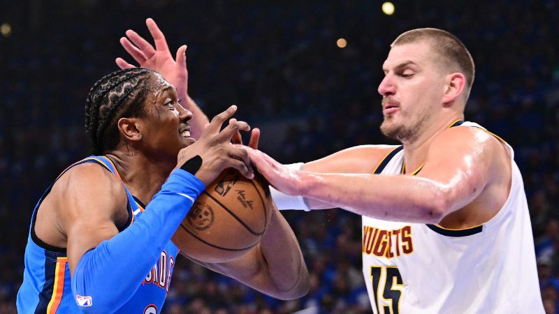 Nikola Jokic de los Denver Nuggets controla el balón mientras Jalen Williams del Oklahoma City Thunder intenta mantener la posesión.