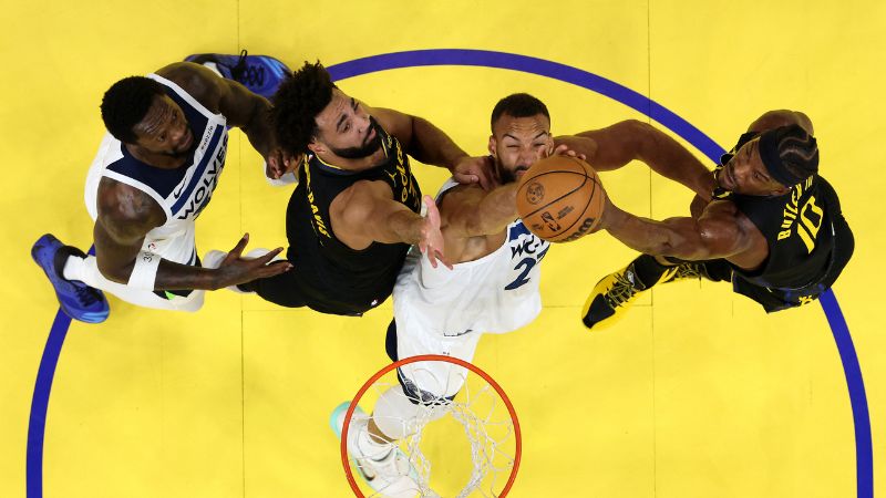 Trayce Jackson-Davis y Jimmy Butler III de los Golden State Warriors luchan por un rebote contra Rudy Gobert y Julius Randle de los Minnesota Timberwolves.