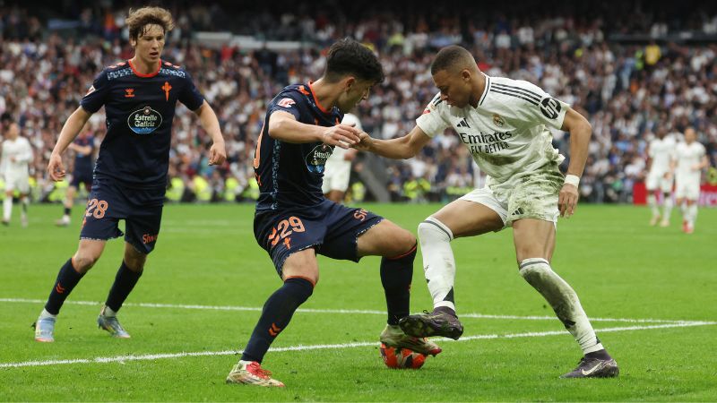 El defensa español del Celta de Vigo, Yoel Lago, y el delantero francés del Real Madrid, Kylian Mbappé, luchan por el balón.