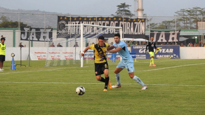 El delantero paraguayo de Génesis Comayagua, Roberto Moreira, es presionado por el defensa motagüense, Sebastián Cardozo.