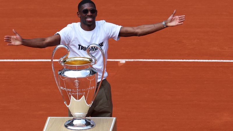 El delantero francés del Paris Saint-Germain, Ousmane Dembélé, muestra con orgullo la "Orejona" que se le ganó al Inter de Milán.