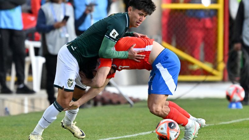 El delantero boliviano Miguel Terceros y el defensa chileno Gabriel Suazo disputan el balón durante el partido de clasificación sudamericana.