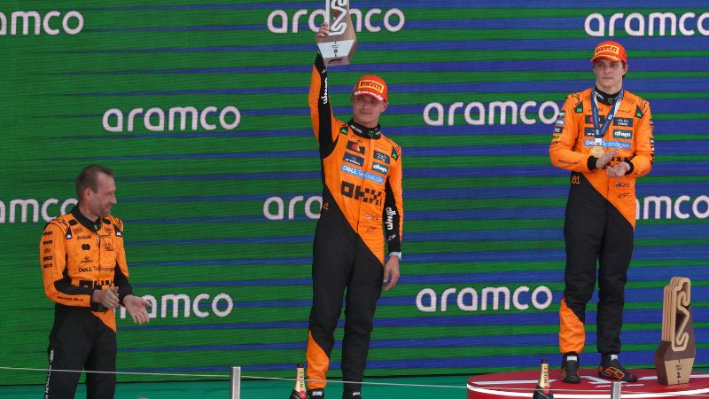 El piloto británico Lando Norris, segundo clasificado de McLaren, levanta su trofeo en el podio junto al ganador, el australiano Oscar Piastri, de McLaren, después del Gran Premio de España de Fórmula 1.