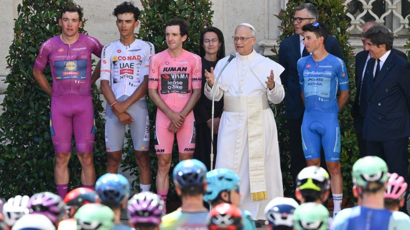 El Papa León XIV pronuncia un discurso flanqueado por el danés Mads Pedersen (Lidl-Trek), con la maglia ciclamino (mejor velocista); el mexicano Isaac Del Toro (UAE Team Emirates XRG), con la maglia blanca (mejor ciclista joven); el británico Simon Yates (Team Visma-Lease a Bike), con la maglia rosa (líder general); el italiano Lorenzo Fortunato (XDS Astana Team), con la maglia azzura (mejor escalador); y el presidente del RCS Urbano Cario.