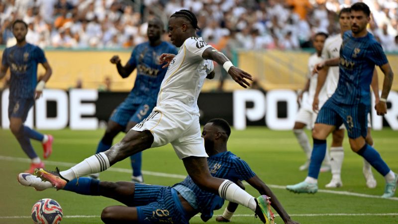 El delantero brasileño del Real Madrid, Vinicius Junior, y el centrocampista portugués del Al Hilal, Ruben Neves, luchan por el balón.
