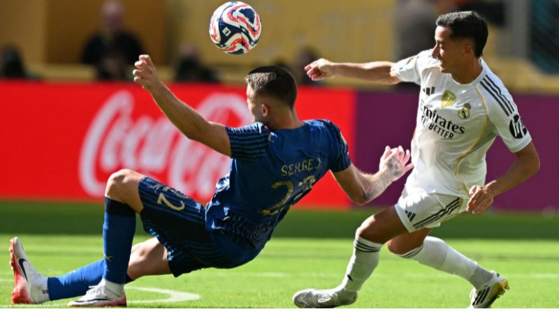 El centrocampista serbio del Al Hilal, Sergej Milinkovic-Savic, lucha por el balón con el defensa español del Real Madrid, Lucas Vázquez.