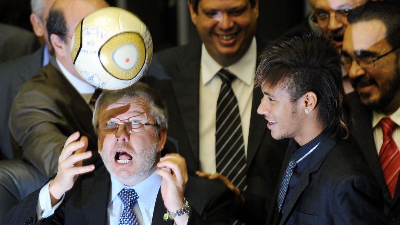 Marco Maia, presidente de la Cámara de Diputados de Brasil, cabecea un balón mientras el futbolista del Santos, Neymar, observa.