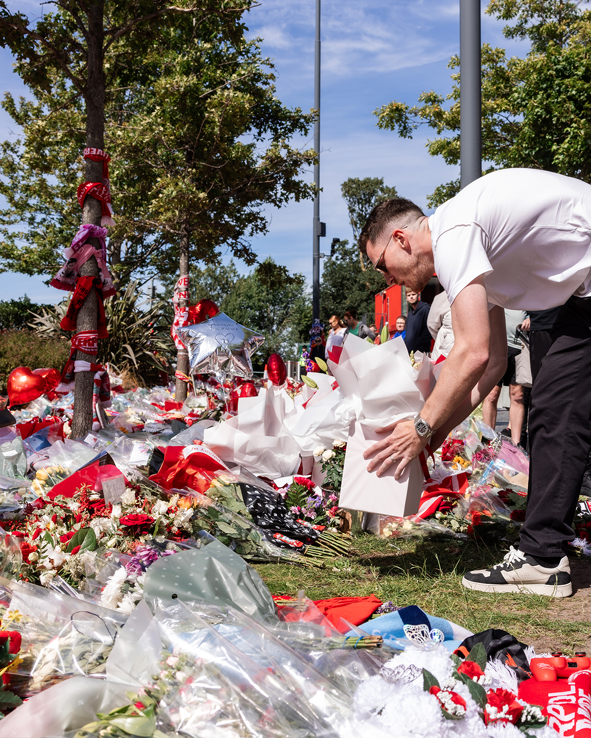 Aficionados del Liverpool llevaron arreglos florales en memoria de Diogo Jota.