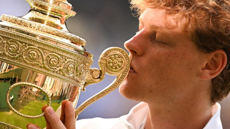 El italiano Jannik Sinner besa el trofeo del ganador mientras posa para fotos después de su victoria contra el español Carlos Alcaraz.
