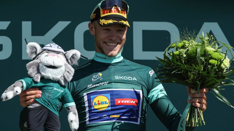 El ciclista italiano Jonathan Milan, del equipo Lidl-Trek, celebra en el podio con el maillot verde de mejor velocista.