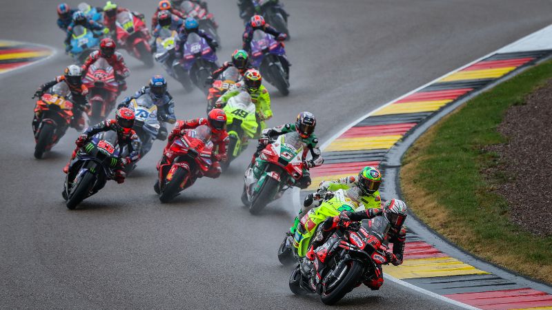 El piloto italiano de MotoGP del equipo Aprilia Racing, Marco Bezzecchi, lidera el grupo en la primera vuelta durante la carrera sprint del Gran Premio de Alemania de MotoGP.