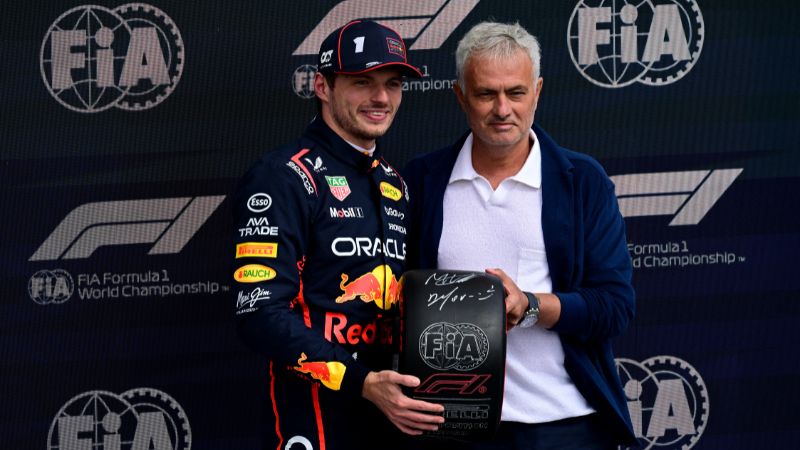 El piloto holandés de Red Bull Racing, Max Verstappen, sostiene el neumático de la Pole Position junto al entrenador de fútbol portugués José Mourinho.