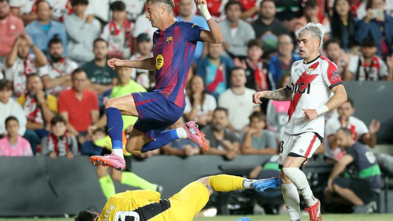El delantero polaco del Barcelona, Robert Lewandowski, se enfrenta al portero argentino del Rayo Vallecano, Augusto Batalla.