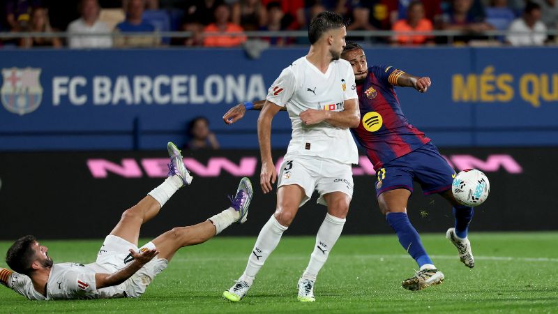 El delantero brasileño Raphinha del Barcelona marca el cuarto gol de su equipo contra Valencia.